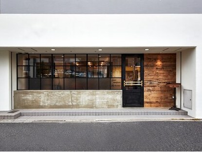 ROOTS.の正面の外観。黒いサッシの窓と木の板壁