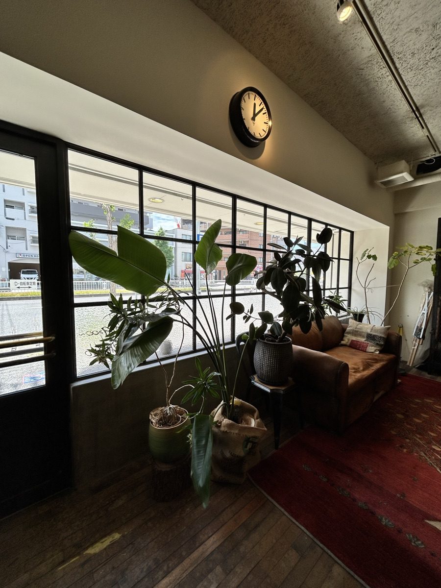 大きな窓と時計、グリーンのある店内